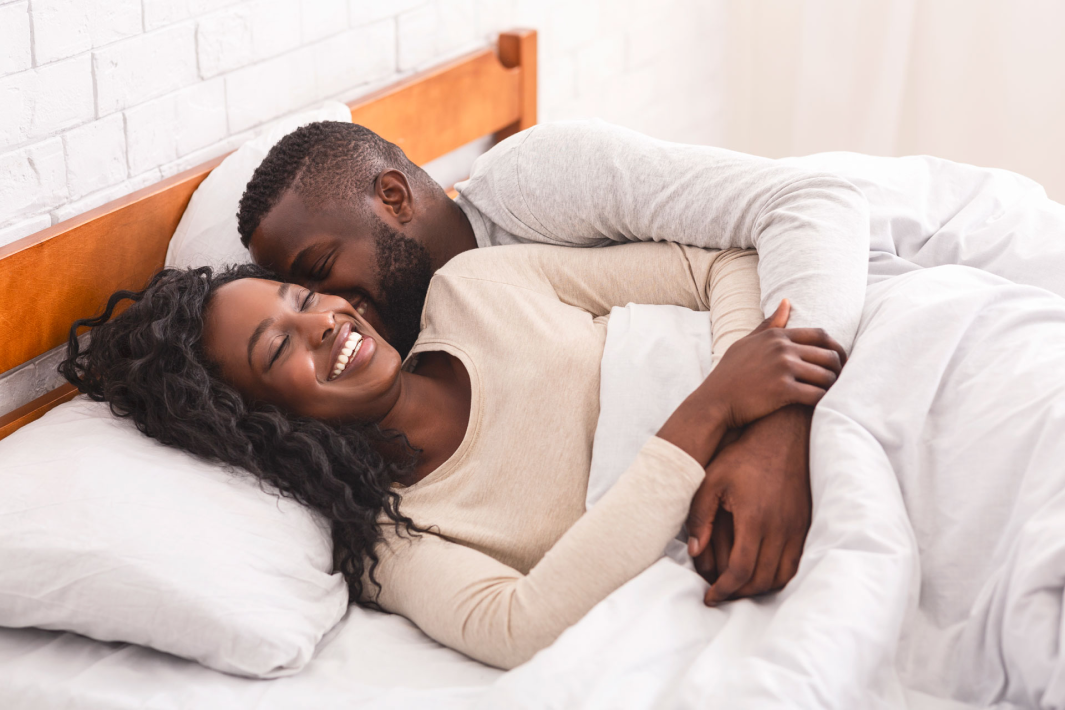 AA-Couple-Home-In-Bed 1 Couple in a comfy bed at home snuggling. Protex at home.